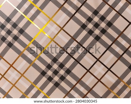 Toned plaid pattern with bold intersecting lines. Golden and brown stripes contrast against soft beige background. Geometric design repeats across entire surface. Suitable for fashion, interior