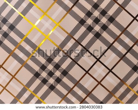 Toned plaid pattern with bold intersecting lines. Golden and brown stripes contrast against soft beige background. Geometric design repeats across entire surface. Suitable for fashion, interior