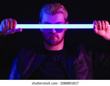 Toned Portrait Of Handsome Young Man With Neon Lamp On Dark Background