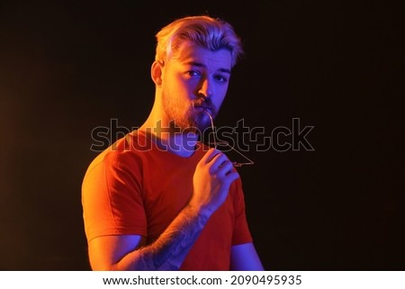 Toned portrait of handsome young man on dark background