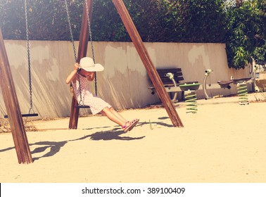 Toned portrait of Little girl in a big hat having fun on a swing  - Powered by Shutterstock