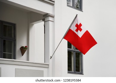 Tonga Flag Hanging On A Pole In Front Of The House. National Flag Waving On A Home Displaying On A Pole On A Front Door Of A Building And Raised At A Full Staff.