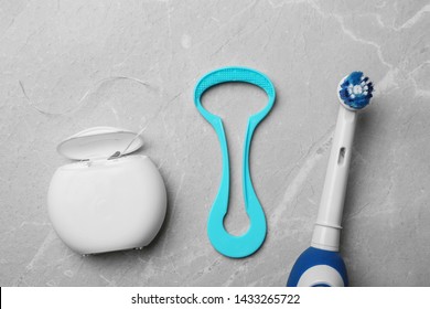 Tongue cleaner, dental floss and electric toothbrush on grey background, flat lay - Shutterstock ID 1433265722
