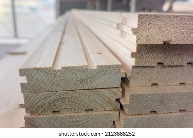 Tongue and groove wooden boards storage. Batten boards with grooves and tongues in market warehouse - Shutterstock ID 2123888252