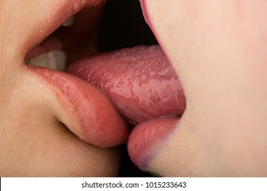 Tongue in lesbian girl mouth, sexy homosexual concept. French Kiss. Two women oral sex. Sensual kiss in same-sex couple close up. Taste and body love for women, sex between girls, homosexual family