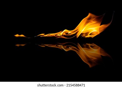 tongues of orange flames with reflection on a black background