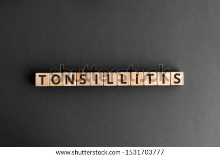 Tonsillitis - word from wooden blocks with letters, tonsils inflammation pharyngitis tonsillitis concept,  top view on grey background