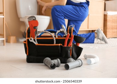 Tool bag with pipes and plumber tools in bathroom, closeup - Powered by Shutterstock