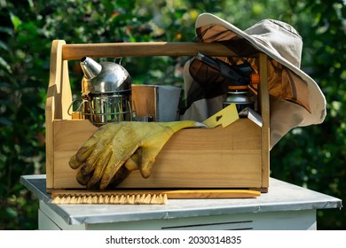 A tool of the beekeeper. Everything for a beekeeper to work with bees. Smoker, a chisel, a box, beekeeper suit for protection from the bees. Beekeeping equipment. Photo on the topic of beekeeping.