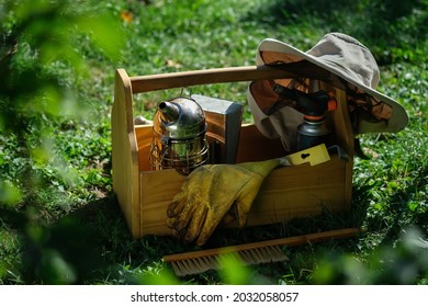 A tool of the beekeeper. Everything for a beekeeper to work with bees. Smoker, a chisel, a box, beekeeper suit for protection from the bees. Beekeeping equipment. Photo on the topic of beekeeping.