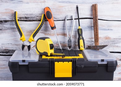 Tool box with different tools on wooden background.