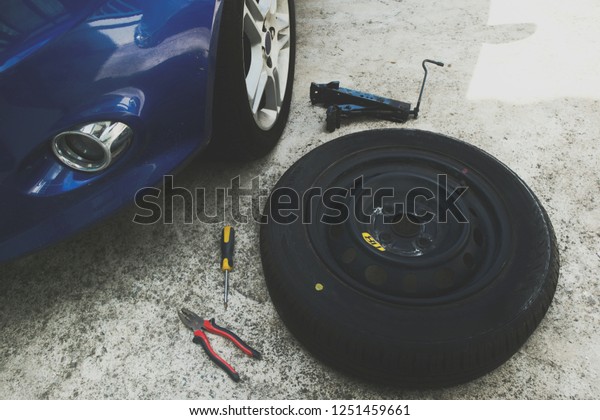 Tool for flat tire\
replacement in the garage consist of spare wheel, jack, wrench and\
screwdriver.