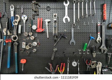 The Tool Hangs On A Black Wall. Organized And Clean In The Shop.