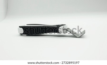 Tool for installing stretch ceilings. A tool with a handle and a metal scraping blade is shown on a plain background. This tool is used to remove materials from different surfaces in home or workshop tasks.