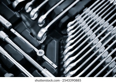 A toolbox with many different sized tools. The toolbox is black and white. The tools are arranged in rows and columns