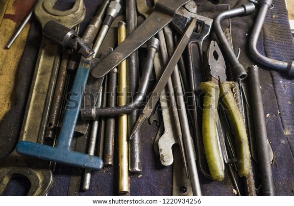 Tools for car and engine maintanance and\
repair, laying on the garage workbench - pliers, wrenches, files,\
hammer, adjustable wrench, socket\
wrenches.