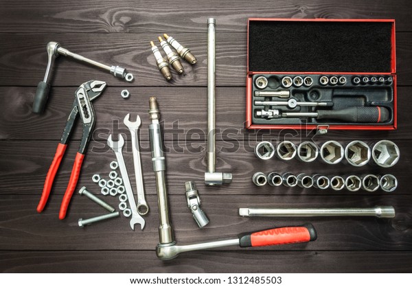 tools and car parts on\
wooden workbench