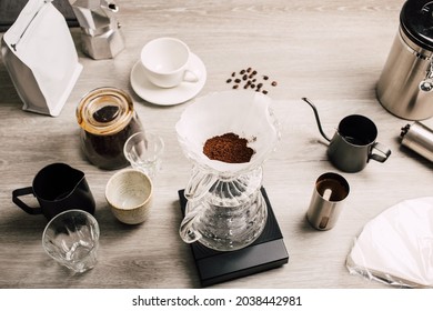 Tools coffee drip with grinding coffee beans with manual stainless steel grinder to make black coffee machine, brewing equipment or coffee drip set Dripper on a wooden table at home top view