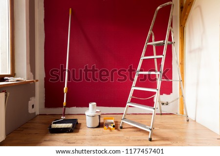 Tools for coloring, paint roller, brush, aluminium leader. Wall partly collored.