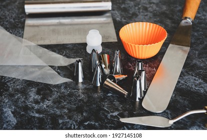 Tools For Creating And Decorating A Cake, Various Spatulas And Cream Tips On The Kitchen Table