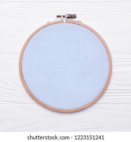 Tools For Cross Stitch. A Hoop For Embroidery And Canvas On White Wooden Background. Mockup About Hobby