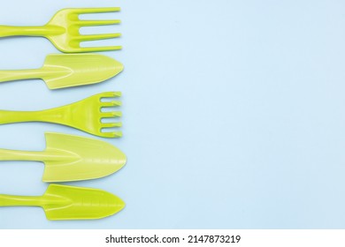 tools for gardening and floriculture, rakes, shovels on a blue background with copy space