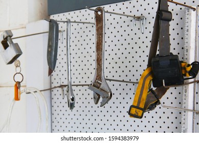 Tools Hangings From A White Pegboard 