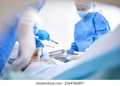 Tools, hospital and surgeon team in theatre for emergency, healthcare or medical procedure. Doctors with a patient for collaboration, scalpel or surgery and operation with support and scrubs in ICU - Shutterstock ID 2364786897