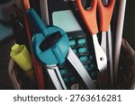 Tools of learning background. A calculator, compass, scissors, and school supplies in a basket with soft focus. Science Technology Engineering and Math themes.