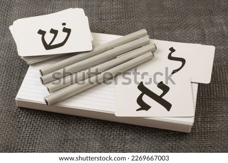 Tools for learning biblical Hebrew of index cards for vocabulary, calligraphy pens and alphabet flash cards: letters Aleph on right (A), Lamed (L) upper right, and Shin (sh sound) (upper left)