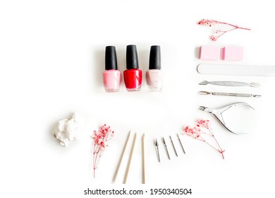 Tools Of A Manicure Set On A White Background. Bottles Of Nail Polish And Tools Around.