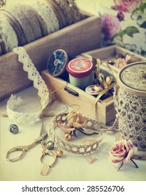 Tools for needlework, thread for sewing, scissors, buttons and vintage laces. Toned image 
