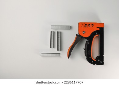 tools. on a light orange construction stapler and staples. for advertising banners of construction label stores and more