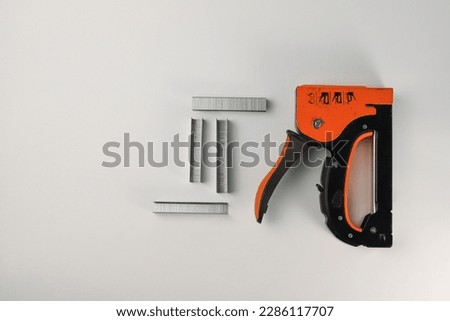 tools. on a light orange construction stapler and staples. for advertising banners of construction label stores and more