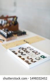 Tools on white table, grey background, workers table with jewelry making tools, home workshop