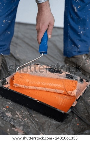Tools for the painter and redecoration. Close-up of orange paint and roller brush in the tray. Close-up [[stock_photo]] © 