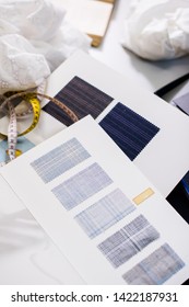Tools, patterns and fabric samples on the sewing table in the tailor workshop