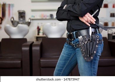 Tools Of A Professional Hairdresser Neatly Stored In A Leather Belt And Pouch Worn Around Her Waist In The Hair Salon