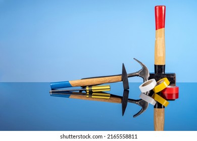 Tools For Repair And Construction, A Sledgehammer And Smaller Hammers, A Screwdriver And Colored Tape. Do It Yourself Concept, Sale Of Goods For Renovation And Construction, Home Renovation Services.