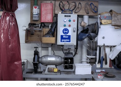 Tools and safety equipment in a workshop emphasizing the importance of protective eyewear