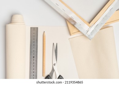 Tools for stretching canvas on a wooden frame top view. Canvas, pencil, scissors ruler and wooden stretcher with canvas roll