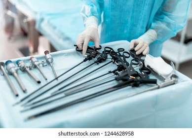 Tools for surgery. Close up of female hand holding laparoscopic scissors or grasper