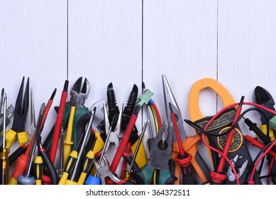 Tools to use in electrical installations on wooden background