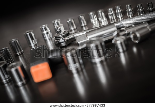 Tools\
for use with nuts. Metal Work. Box wrench head bits for the\
screwdriver and other tools on a dark\
background