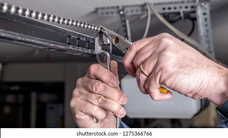 Tools are used to work on a garage door opener chain 