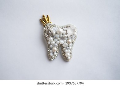 Tooth from beads and crystals on white background