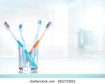 Zahnbürsten aus Glas auf Tisch gedecktem Badezimmer-Hintergrund.Tothbürste Dentaldesign Konzept.