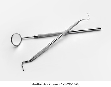 Tooth explorer and dental mirror on white background