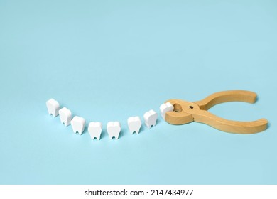 Tooth extraction with a dental instrument with forceps.  A model of teeth in the shape of a smile. Problems with wisdom teeth, toothache - Shutterstock ID 2147434977