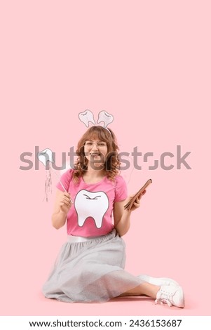 Tooth Fairy with wand and notebook on pink background